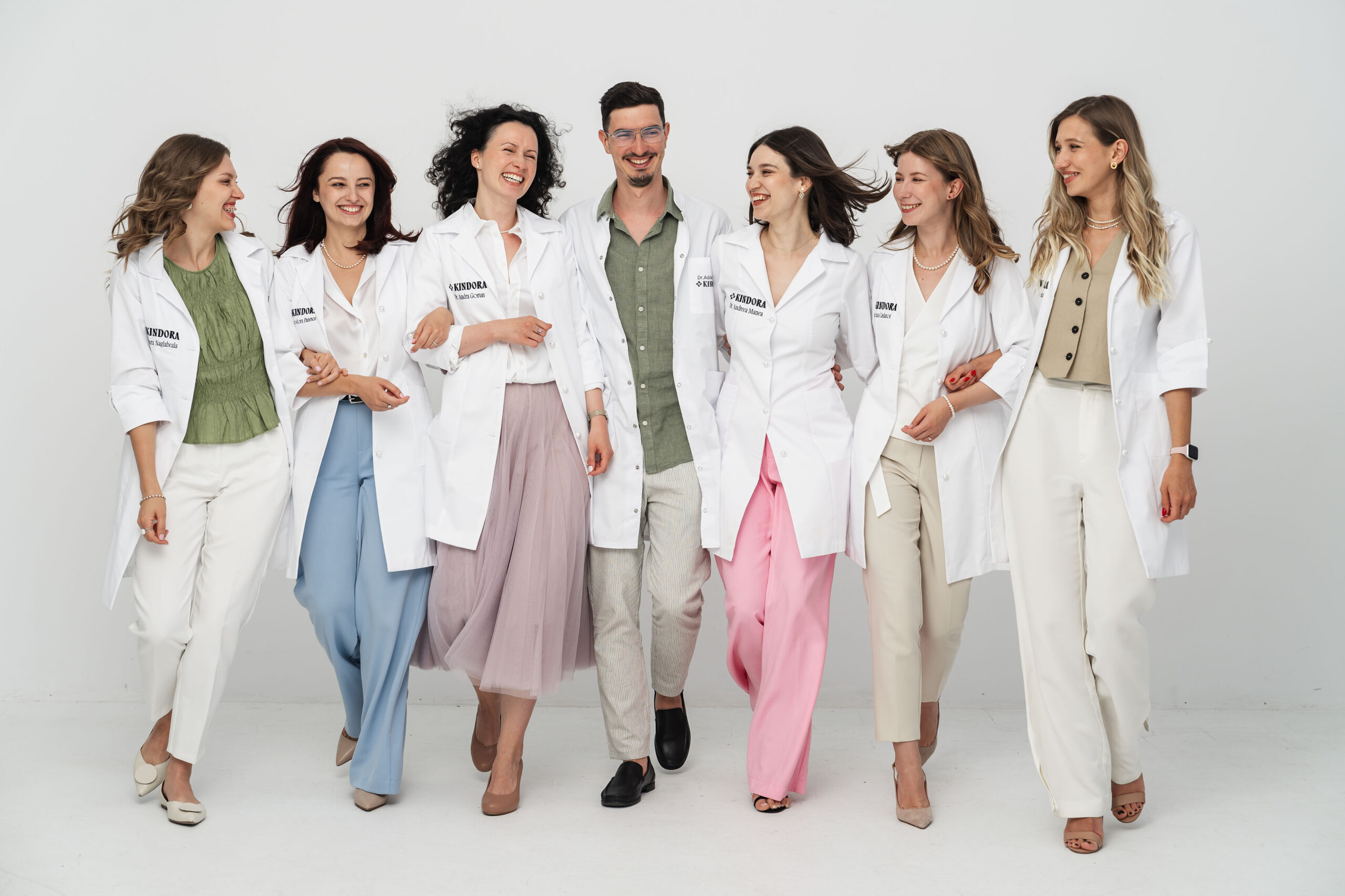 echipa de experti medici nutrionisti Kindor, cu halate albe, merg, zambesc